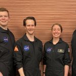 Четыре участника миссии NASA CHAPEA-2 в черных комбинезонах внутри модуля