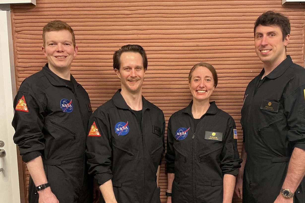 Четыре участника миссии NASA CHAPEA-2 в черных комбинезонах внутри модуля