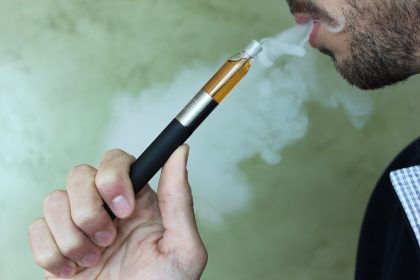 Человек держит электронную сигарету