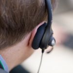 Сотрудник колл-центра в гарнитуре за рабочим местом